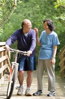older couple biking in park
