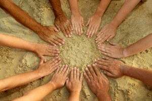 12 hands in a circle in the sand representing Ministry Insights relationships