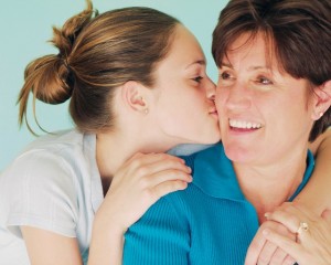 Teenage daughter kissing mom on the cheek