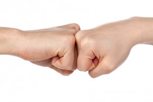 fist bump between 2 adults demonstrating strength in numbers when parenting